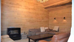 Una sala de estar acogedora con chimenea, sofás de cuero y televisor.