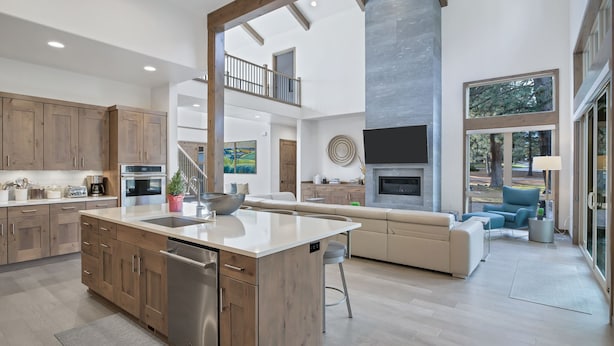 A spacious kitchen with wooden cabinets, a large island, and a built-in oven. - Deschutes Executive Retreat - 6BR Luxury Rental (Deschutes County)