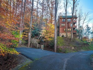 A multi-story building with a red exterior, surrounded by trees with autumn foliage.