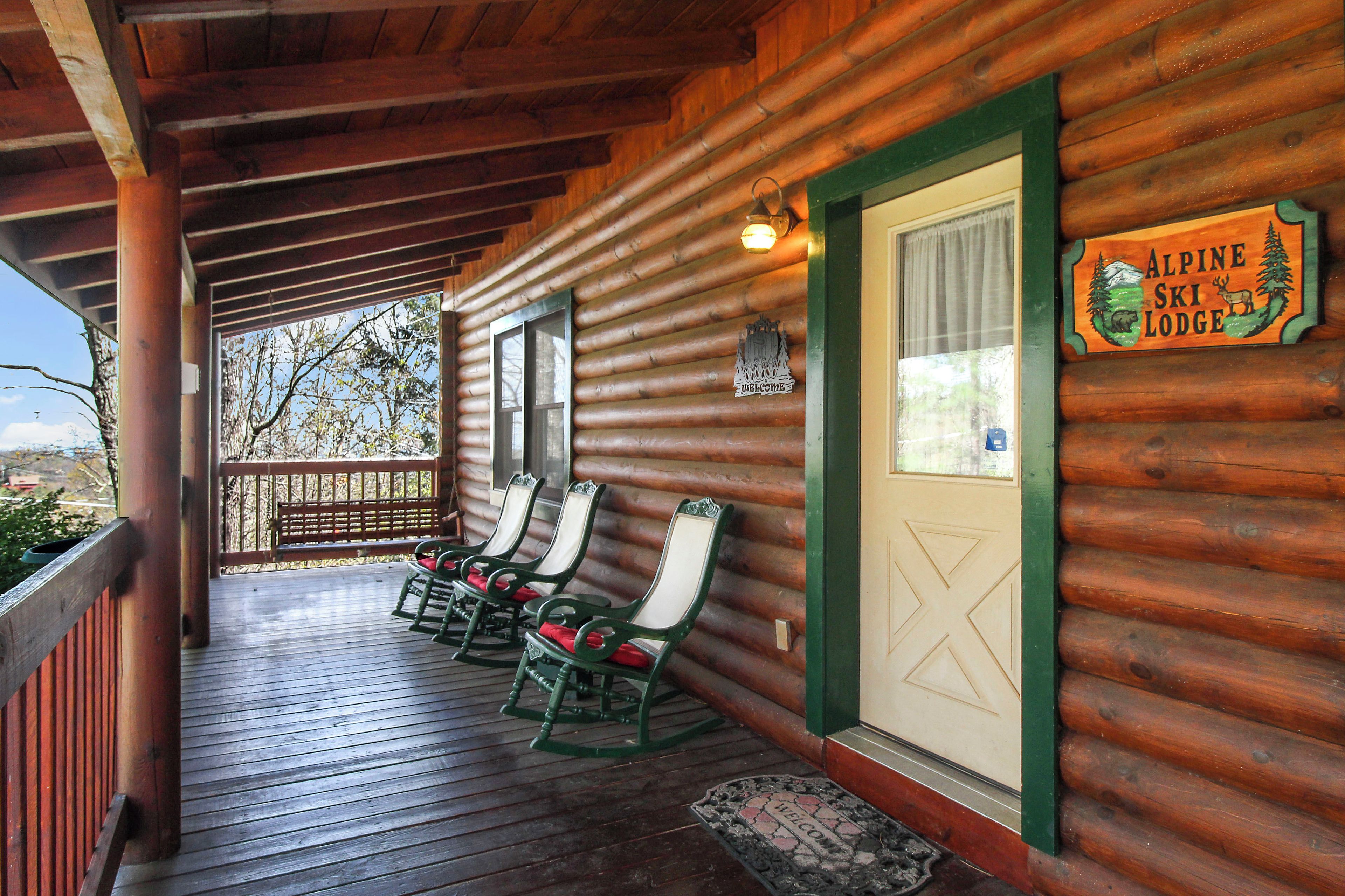 A wooden lodge with a porch featuring rocking chairs and a sign reading "Alpine Ski Lodge".