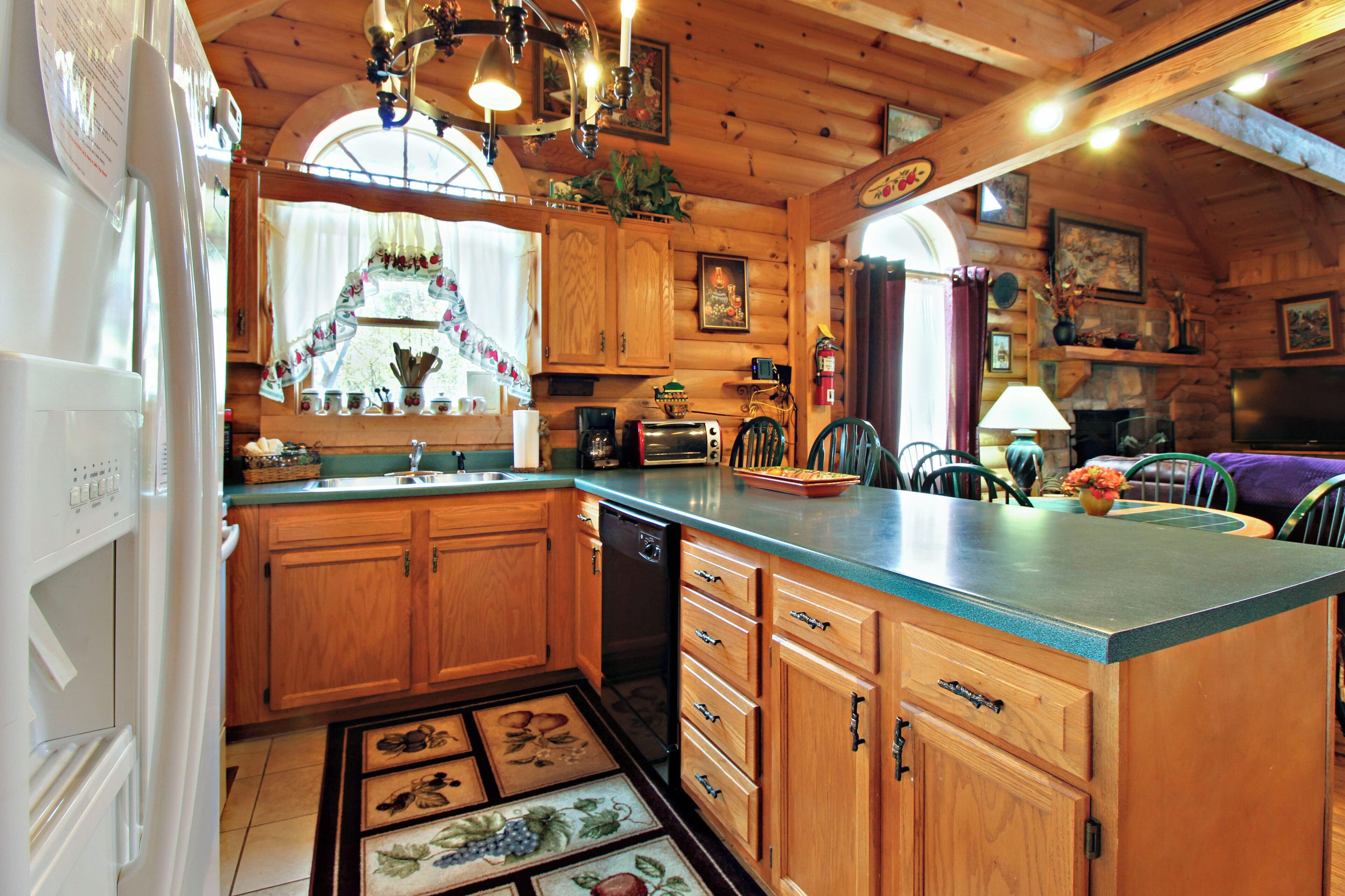 A wooden cabin kitchen with a central island, wooden cabinets, and a built-in dishwasher.