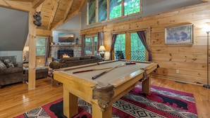 A cozy lodge with a pool table, a fireplace, and a comfortable seating area. - Above Ole Smoky's Clouds by Jackson Mountain Rentals (Gatlinburg)