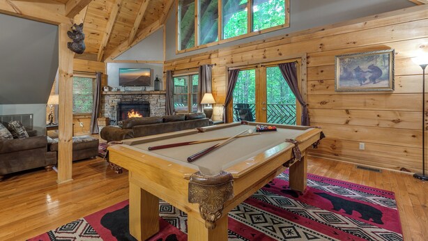 A cozy lodge with a pool table, a fireplace, and a comfortable seating area. - Above Ole Smoky's Clouds by Jackson Mountain Rentals (Gatlinburg)