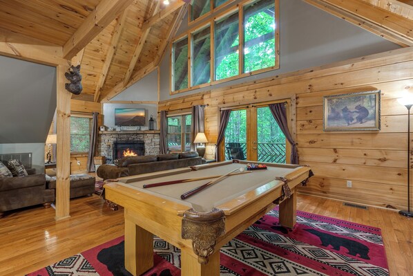 A cozy lodge with a pool table, a fireplace, and a comfortable seating area. - Above Ole Smoky's Clouds by Jackson Mountain Rentals (Gatlinburg)