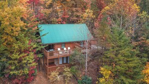 A cabin with a balcony, surrounded by autumn foliage. - Americana by Jackson Mountain Rentals (Gatlinburg)