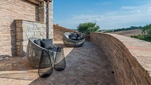 A rooftop terrace with stone walls, two wicker chairs, and a view of the countryside. - Villa Flavia - Private villa, 6 bedrooms, pool, A/C, wifi, pets, Marche (Filottrano)