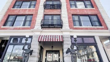 Classic architecture meets elegant design at Belvano, featuring a red brick and white stone facade with black-framed windows and a charming entrance.