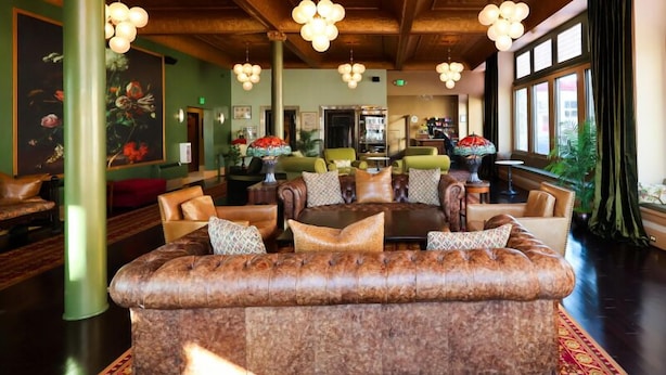 A spacious lobby with a large leather sofa, multiple seating areas, and hanging spherical light fixtures. - Belvada Hotel (Tonopah)