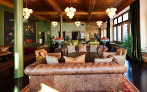 A spacious lobby with a large leather sofa, multiple seating areas, and hanging spherical light fixtures. - Belvada Hotel (Tonopah)
