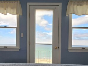 Una habitación con puerta a un balcón con vista a la playa.