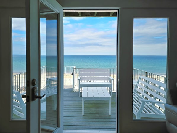 Vista desde una habitación con puerta que da a un balcón con vistas a la playa.