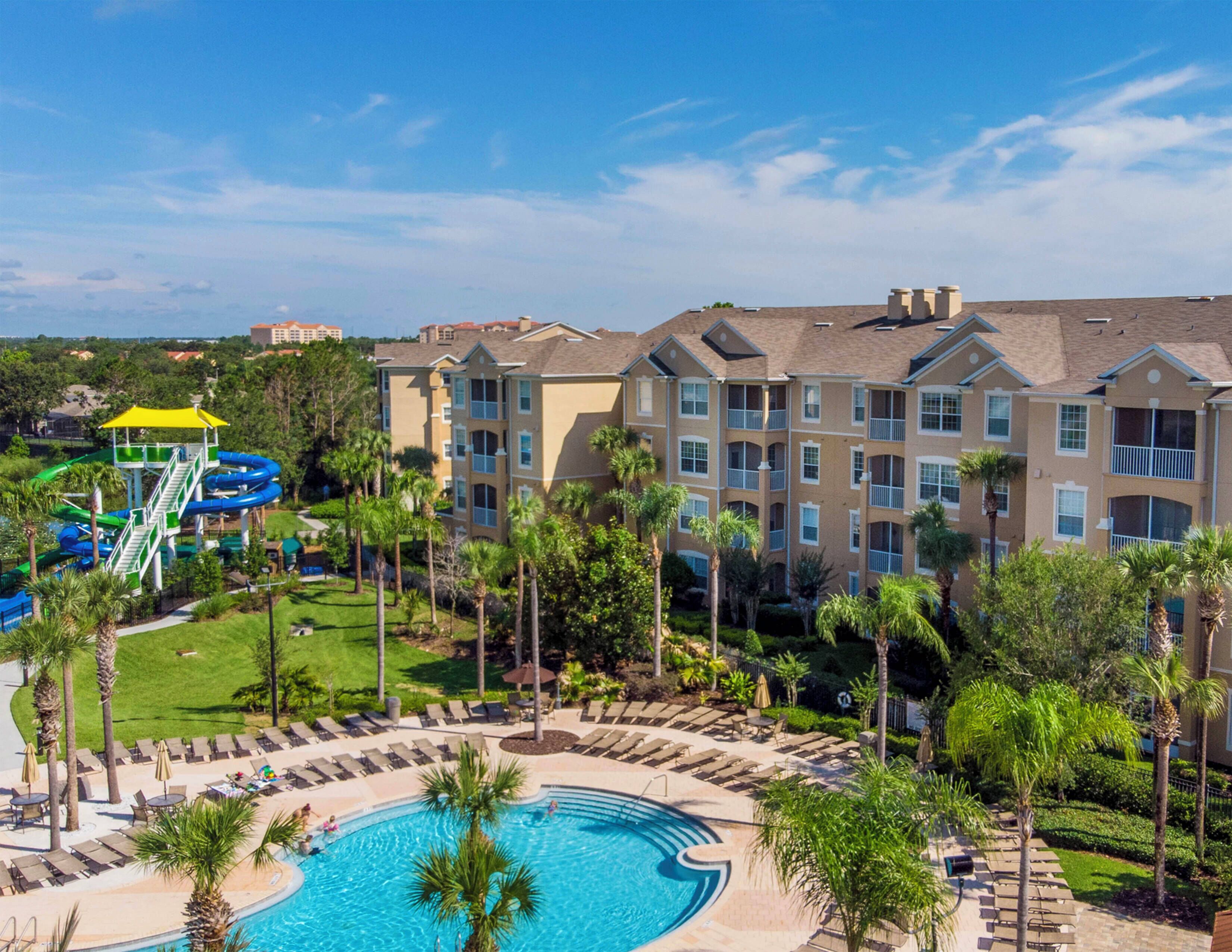 A resort with a swimming pool, lounge area, and water park.