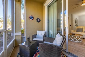 A balcony with wicker furniture, a glass door, and a view of the outside. - Windsor Hills Dream - 3BR - 2 miles from Disney! (Kissimmee)