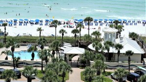 A beach resort with a swimming pool, beach umbrellas, and palm trees. - Sea Breeze, Destin Studio, Pools, Beach (Destin)