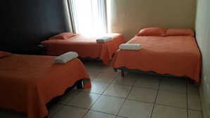 A room with three beds, each with an orange bedspread and a white towel on the bed. - RAGOL 502 ALMERIA MONTERREY MINUTOS DE AEROPUERTO (ALMERIA)
