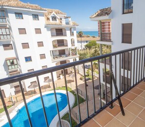 A balcony with a view of a swimming pool and other buildings.