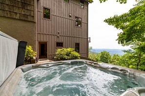 A hot tub with a view of a building and trees.
