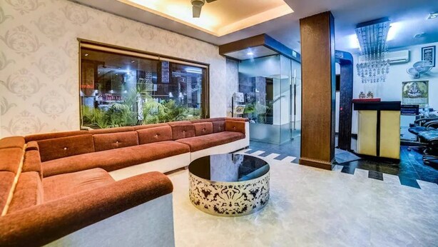 A modern living room with a sofa, a coffee table, and a ceiling fan. - Cosmo Hotel (New Delhi)