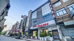 A hotel named 'HOTEL COSMO' with a modern facade, large windows, and a visible entrance. - Cosmo Hotel (New Delhi)