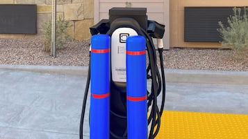 A charging station with two blue cylindrical batteries connected to a black device.