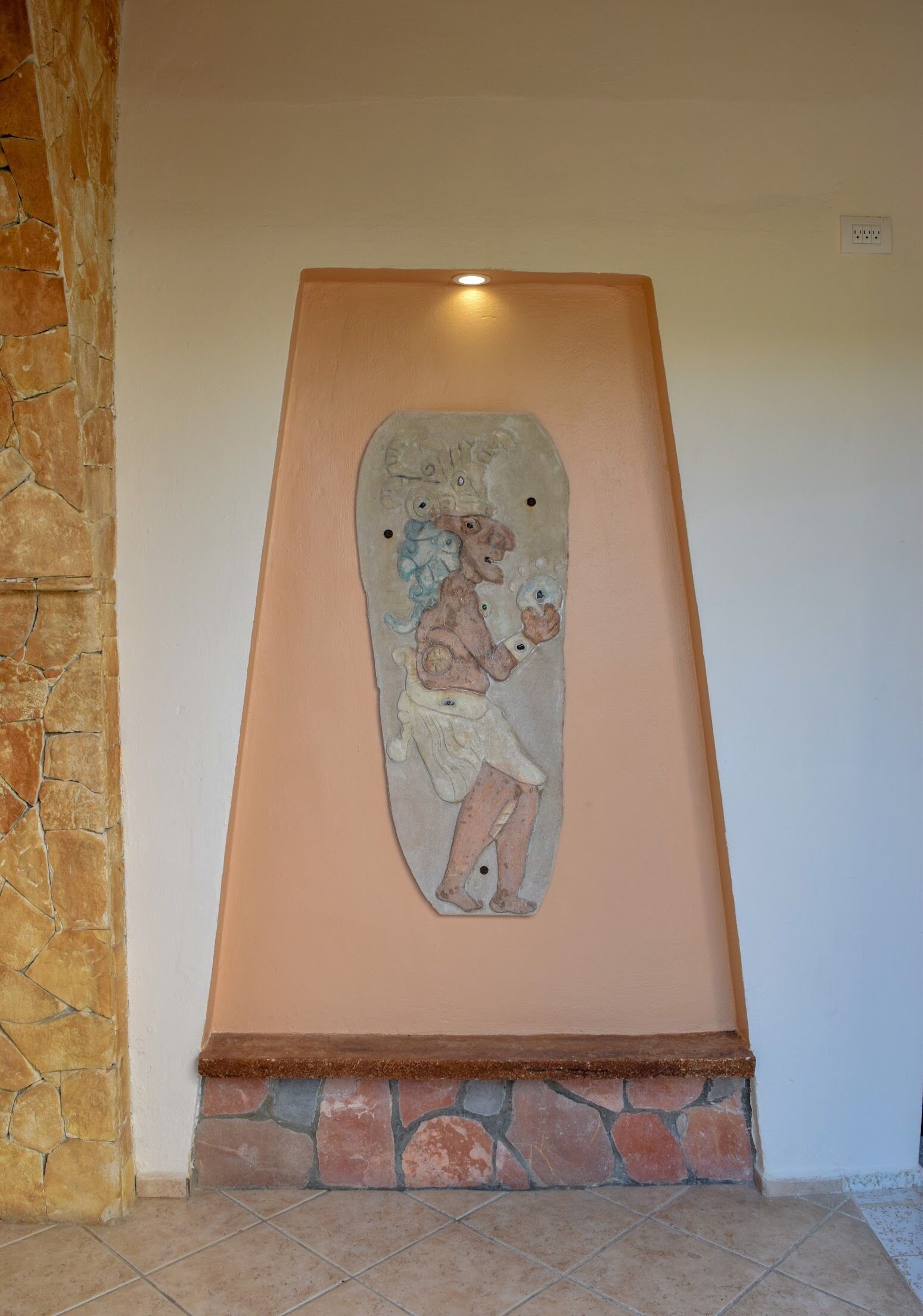 A stone fireplace with a decorative panel featuring a figure.