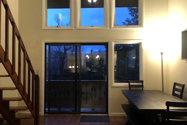 Dining table area with slider to wrap around deck and stairs to loft