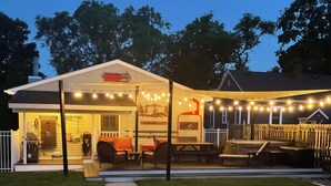 A house with a covered porch, outdoor seating, and string lights. - Downtown TC Home (Traverse City)