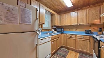 A kitchen with wooden cabinets, a refrigerator, a microwave, and a toaster.