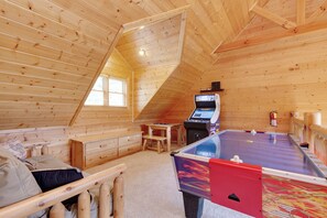 A cozy wooden room with a foosball table, a small desk, and a window. - Changes in Latitude by Jackson Mountain Rentals (Gatlinburg)