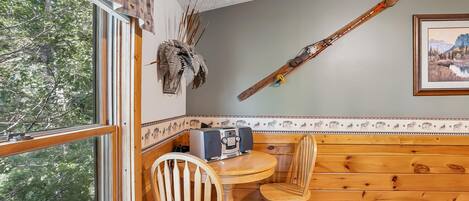 A wooden interior with a dining area, a pool table, and a ski on the wall.