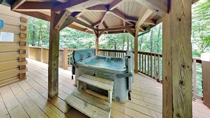 A wooden deck with a hot tub and a wooden bench. - Big Bear 2 (Gatlinburg)