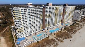 A high-rise hotel with multiple balconies, a swimming pool area, and a beach view. - NO OWNER FEES! Gorgeous Updated OCEANFRONT 2/2 Suite, OF Master, W/D, 18th Fl (North Myrtle Beach)
