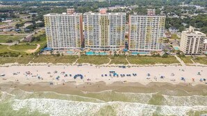 A beachfront hotel with multiple high-rise buildings, a sandy beach, and a swimming pool area. - NO OWNER FEES! Gorgeous Updated OCEANFRONT 2/2 Suite, OF Master, W/D, 18th Fl (North Myrtle Beach)