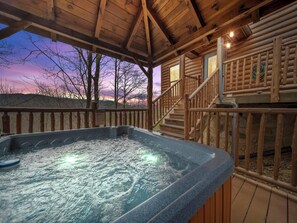 Ein Whirlpool in einer Holzhütte mit Blick auf den Sonnenuntergang.