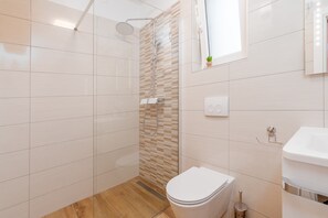 Ein modernes Badezimmer mit Dusche, Toilette und Waschbecken.