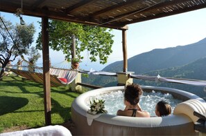 A hot tub with a view of mountains, a hammock, and a wooden pergola. - In complete silence with a view of the sea (Crova)