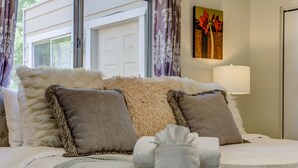 A neatly made bed with multiple pillows and a blanket, a lamp, and a painting on the wall. - Agave House, Views Of Chimney Rock, Pets OK! (Sedona)