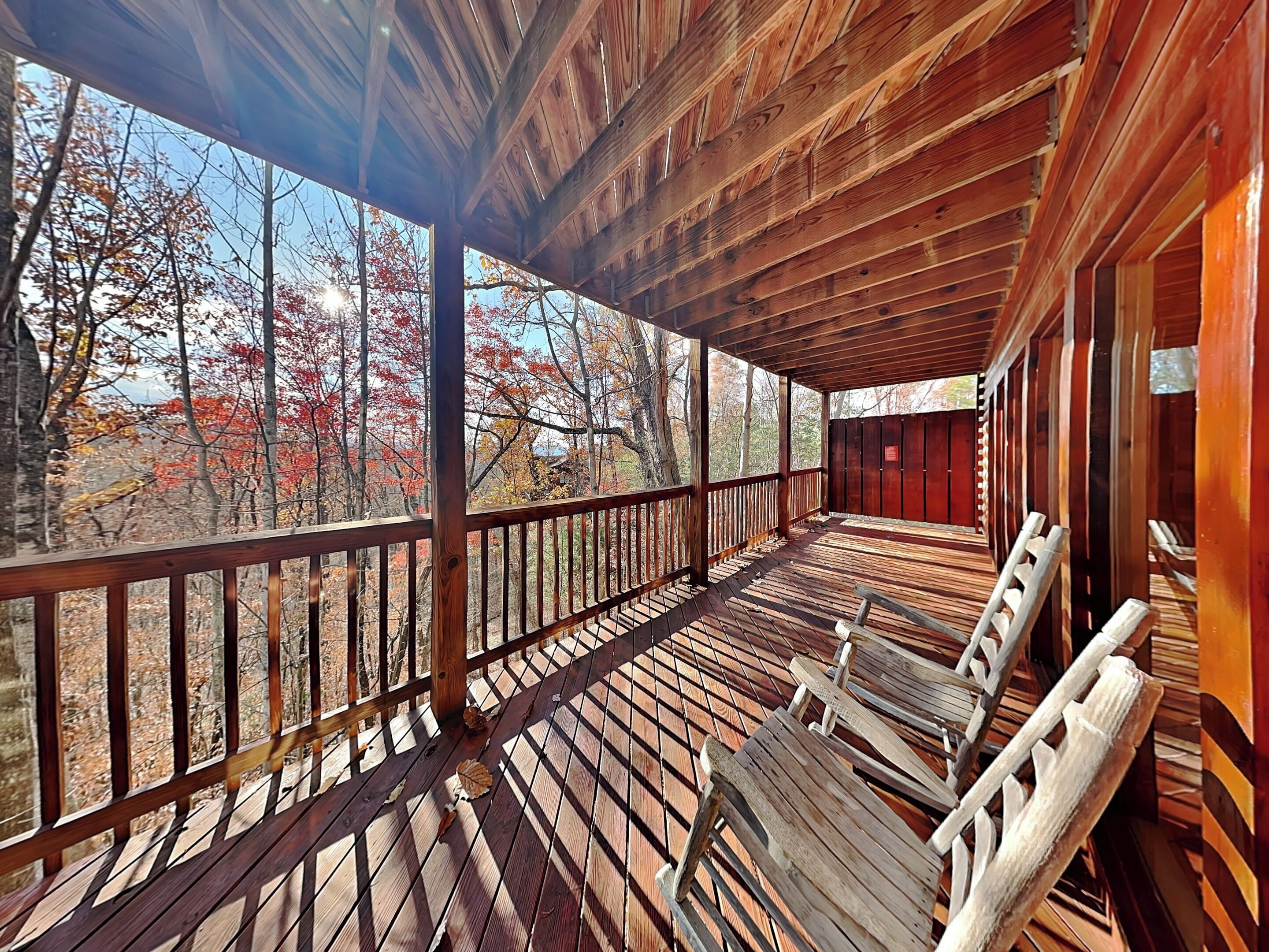 A wooden deck with a railing, a bench, and a ladder.