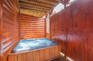 A wooden cabin with a hot tub in the center. - Hemlock Inn by Jackson Mountain Rentals (Gatlinburg)