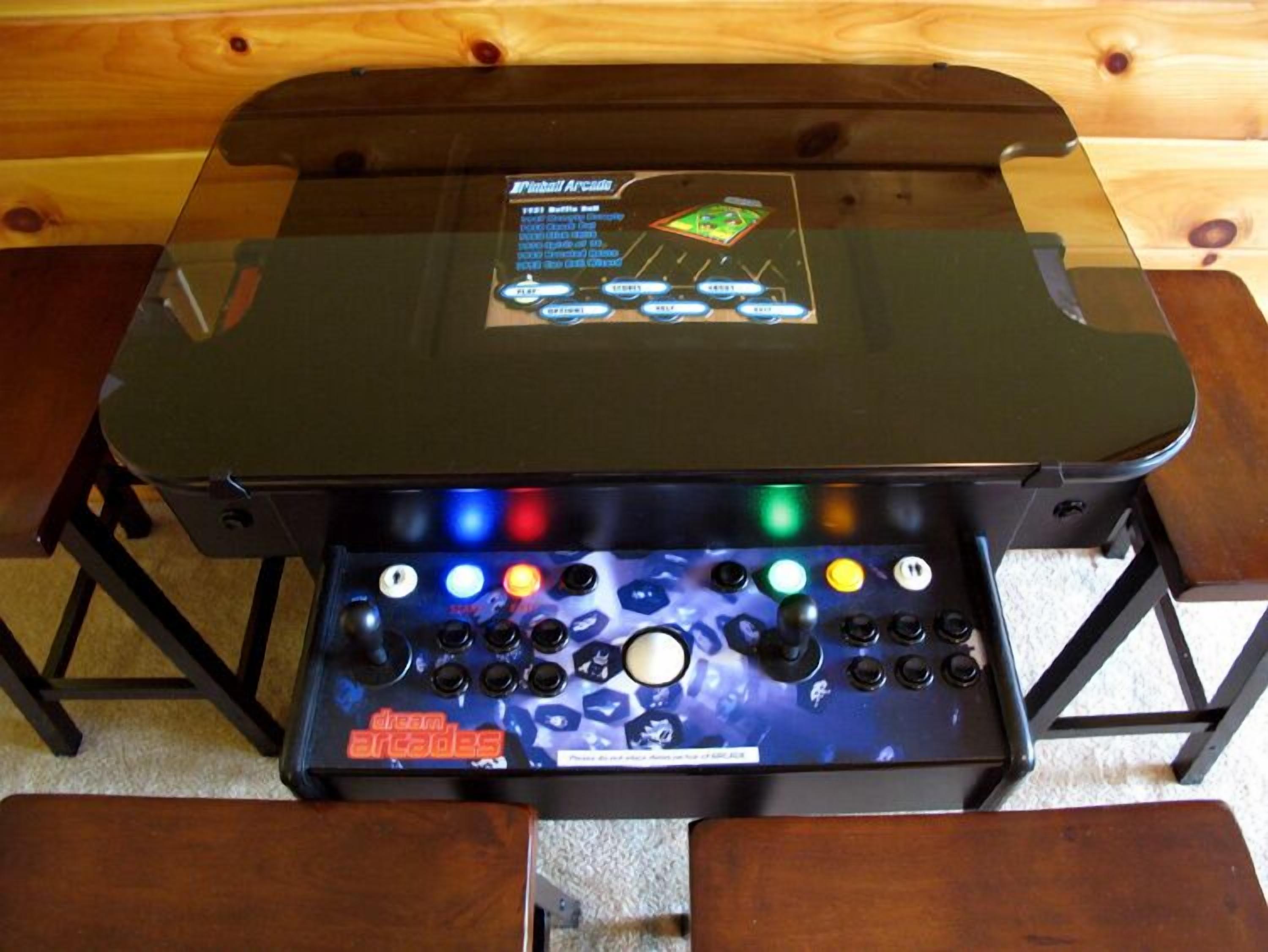 A gaming console with a transparent top and a control panel with multiple buttons and a joystick.