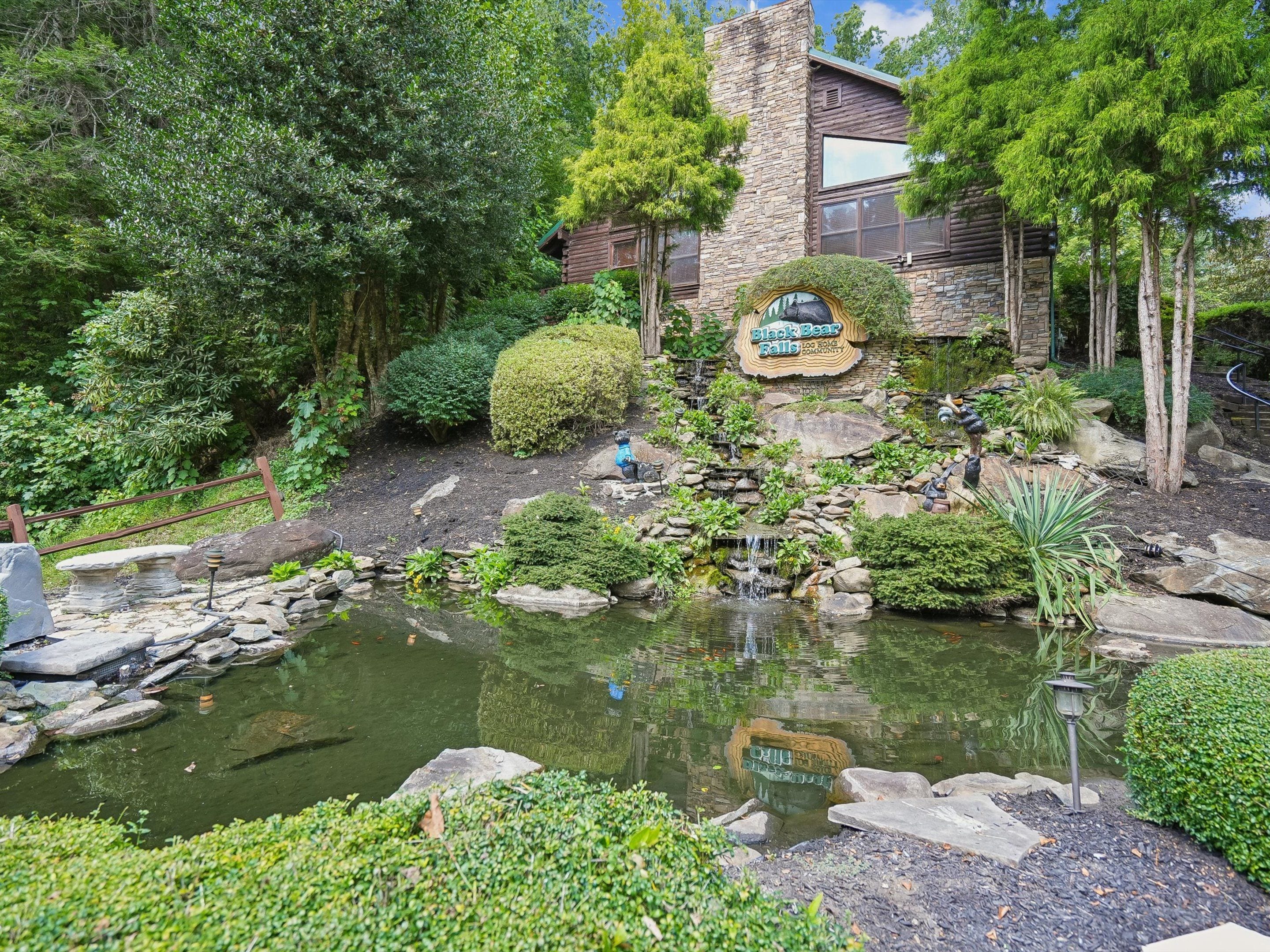 A landscaped garden with a pond, stone walls, and a wooden cabin labeled 'Black Bear Falls.'