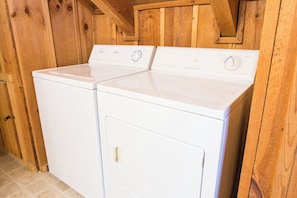 A laundry area with two white front-loading washing machines. - Fox Den by Jackson Mountain Rentals (Gatlinburg)