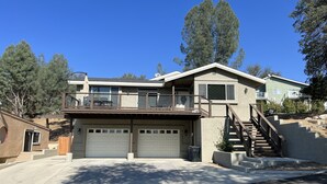 Une maison à deux étages avec un garage, un balcon et un escalier menant à l’étage supérieur.