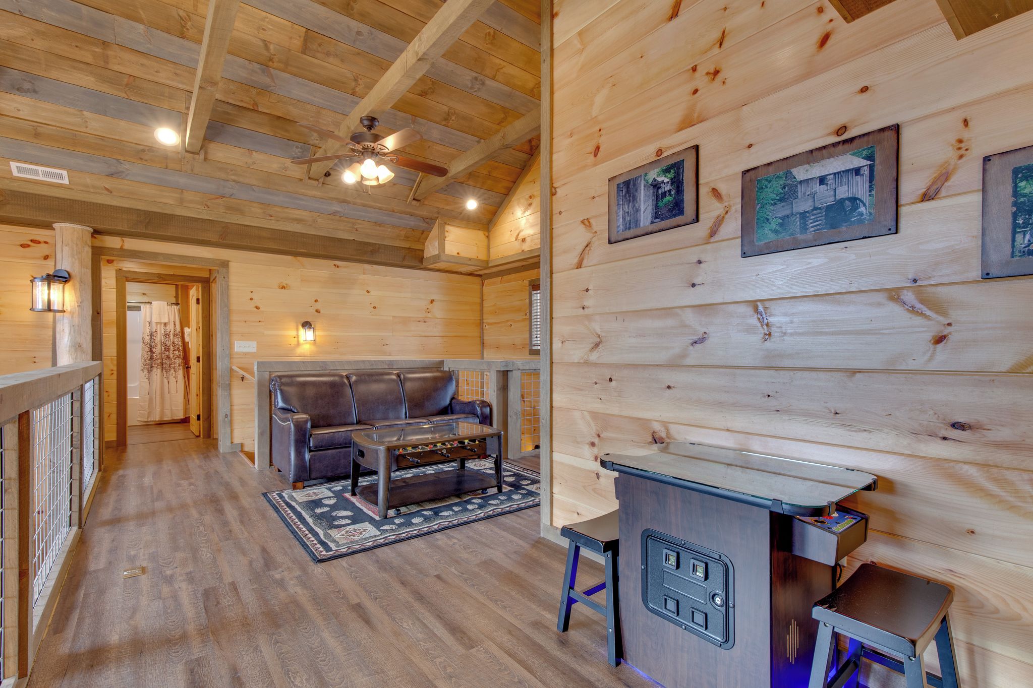 Un intérieur chaleureux en bois, avec un canapé, un baby-foot et un coin bar.