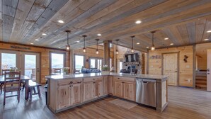 A spacious kitchen with wooden cabinetry, a central island, and pendant lighting. - Great Smoky Lodge by Jackson Mountain Rentals (Gatlinburg)