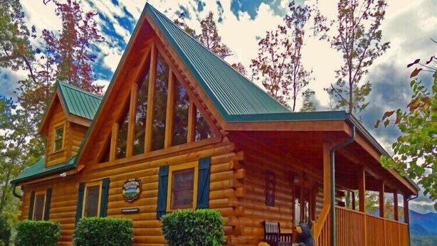 Una cabaña de troncos con un porche, una chimenea y un cartel que indica que es una posada.