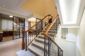 A staircase with wooden handrails and black metal balusters leading to an upper floor. - Qiandaohu Kaiyuan Life Hotel (Chun'an)