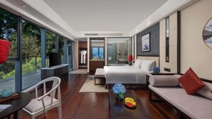 A modern hotel room with a large bed, a sofa, a dining table, and a view of the outdoors. - Qiandaohu Kaiyuan Life Hotel (Chun'an)