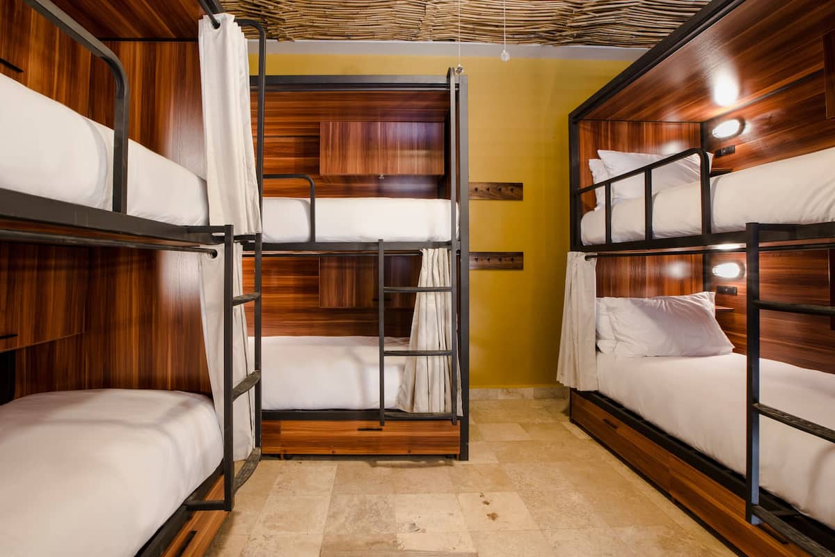 A bunk bed room with wooden walls and a tiled floor.