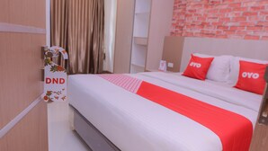Een hotelkamer met een bed, een kledingkast en een muur met een baksteenmotief.